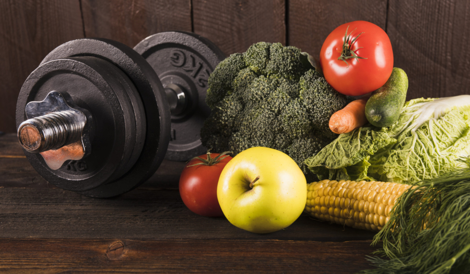 fresh-vegetables-dumbbells-wooden-background